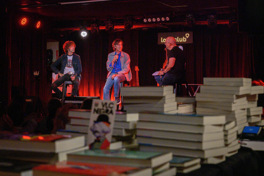 Benjamín Prado y Javier Menéndez Flores conversan sobre el escenario del Loco Club bajo la moderación de Santiago Álvarez.